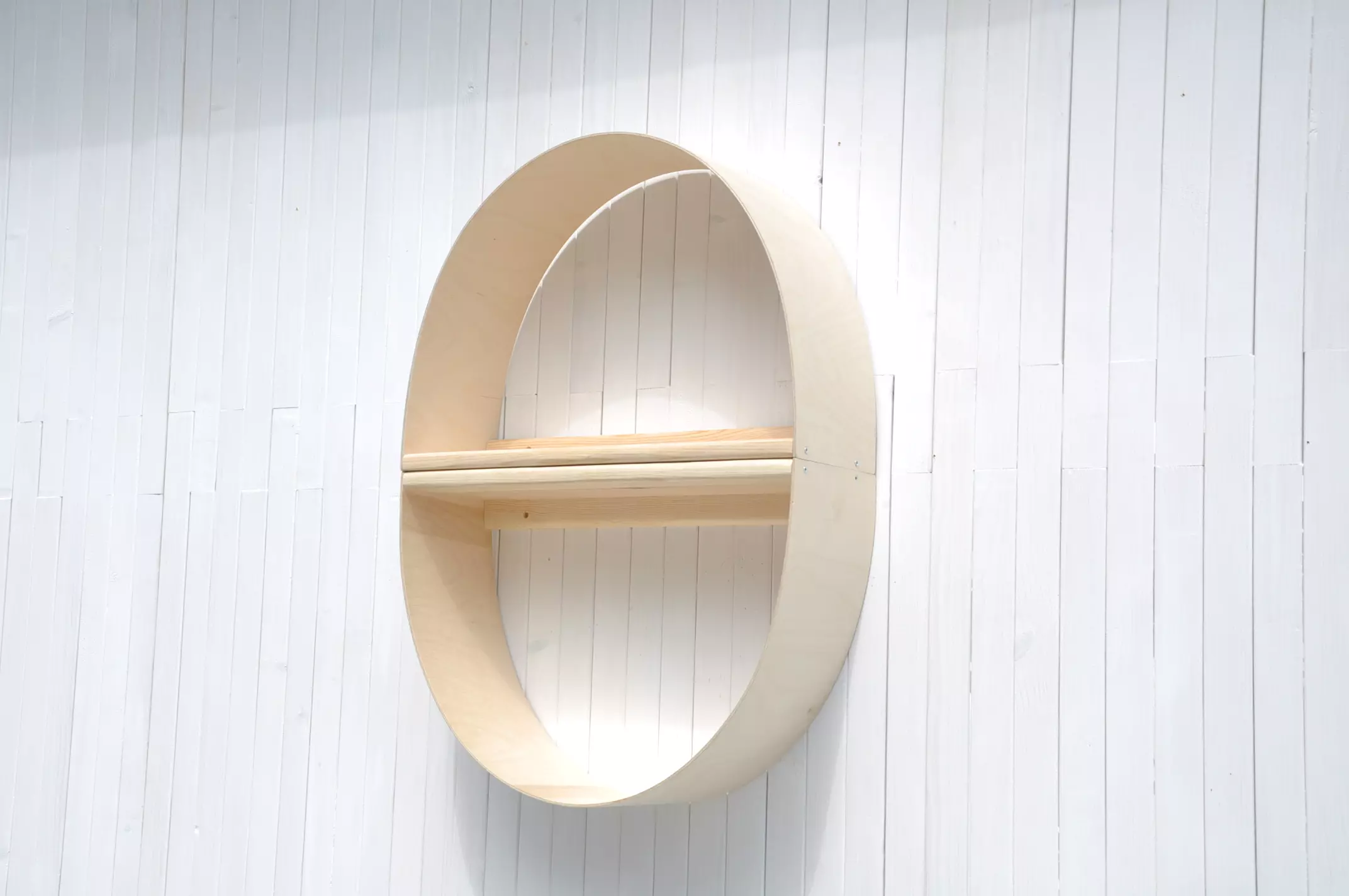 Apaļš sienas plaukts Ola ar plauktiem rotaļlietām un grāmatām.